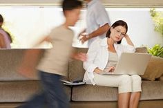 a woman sitting on top of a couch with a laptop computer in front of her