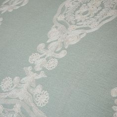 an upholstered green and white fabric with floral designs on the bottom half of it