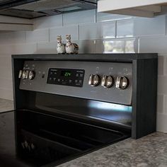 an oven with two cats sitting on top of it in a kitchen next to a stove