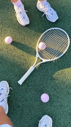 a person standing on the ground with tennis rackets and balls in front of them