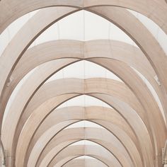 an arched walkway is lined with wooden arches