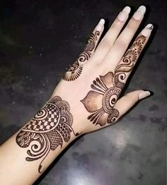 a woman's hand with henna tattoos on it