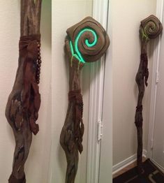 three carved wood sculptures on the wall next to a door with green light coming from them