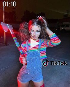 a woman in overalls holding a large knife