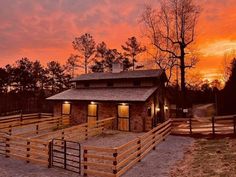 a horse barn at sunset with its lights on