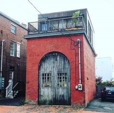 an old brick building with a wooden door and balcony