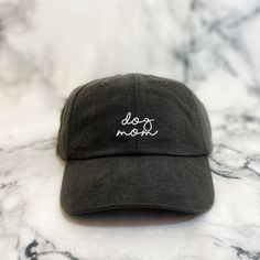 "These are not cheap hats! These hats have thick, garment dyed fabric and leather buckles with quality embroidery. Each hat is custom made with your selections in Memphis by me. If you have a request for a design or want a different saying on the hat or would like \"dog mom\" bigger or smaller, please send me a message and we can get started on a custom order! >> Hat Details << ■100% garment-washed cotton ■Leather strap with antiqued brass buckle ■6-panel, unstructured, low-profile ■ Cheap Breathable Solid Baseball Cap, Trendy Dad Hat With Embroidered Logo, Customizable Dad Hat Baseball Cap, Dog Mom Merch, Everyday Six-panel Dad Hat With Embroidered Logo, Dog Mom Hat, Puppy Hats, Cheap Hats, Boss Brand