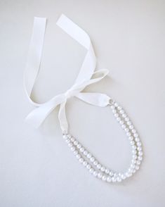 A delicate pearl necklace with a black satin ribbon closure is to add an effortless romantic and classic look to your formal or casual style. Perfect to complete your date night, wedding, bridesmaids, holiday party, and any special occasions. DETAILS:HANDMADEIMPORTED MATERIALS Elegant Bridal Accessories With Satin Bow, Adjustable Pearl Bridal Necklace For Party, Elegant Ribbon Necklaces For Evening, Elegant Evening Necklaces With Ribbon, Elegant Bridal Necklace With Pearl Charm For Formal Occasions, Elegant Evening Necklace With Ribbon, Elegant Jewelry With Ribbon For Wedding, Chic Pearl White Necklace For Wedding, Classic Pearl Bridal Necklace For Party