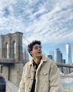 a man standing in front of the brooklyn bridge looking up at something with his mouth open