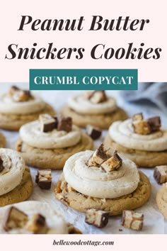 peanut butter snickkers cookies with white frosting and chopped chocolate chunks on top