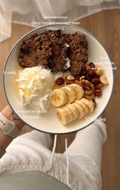 a white plate topped with lots of food on top of a person's hand