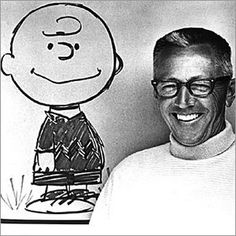 a man standing in front of a drawing of a smiling boy with glasses on his face