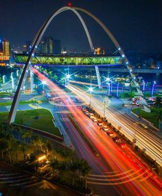 an aerial view of the st louis arch at night, with traffic passing underneath it