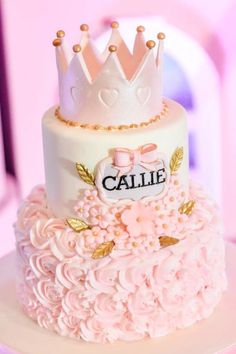 a white cake with pink flowers and a crown on top that says cahie