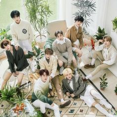 a group of young men sitting next to each other on top of a tiled floor