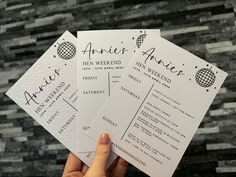 someone holding up three wedding programs in their hand