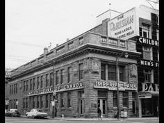 an old black and white photo of the outside of a building with signs on it