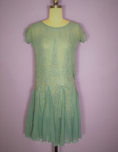 "Beautiful 1920s silk chiffon beaded dress in a light blue color. Has a scoop neckline, cap sleeves, and flutter skirt which is created by diamond shaped beaded and rhinestone vertical embellishments. Condition: very good vintage condition. Has one tiny mend where there is an intersection of two diamonds. Has a small stain on the bodice and at the armpits which I have not attempted to clean Quite minor. Label: none Circa: 1920s Composition: silk Color: blue Size: small Measurements: Shoulder str Draping Dress, Deco Beads, Dresses 40s, Beaded Chiffon, 1920s Art, 1920s Dress, 1940s Dresses, 1920s Art Deco, Blue Silk