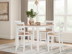 a dining room table with chairs and a potted plant