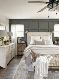 a bedroom with a bed, dressers and ceiling fan in the middle of it