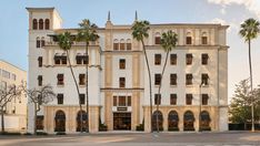 an old building with palm trees in front of it