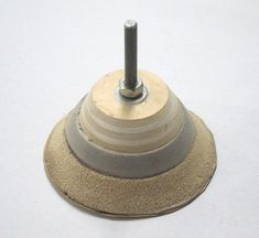 an object that is sitting on top of a white surface with a screw in the middle