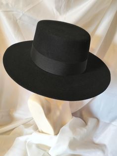 Perfect, black, wool felt, wide brimmed hat  with a low crown and edge cut brim. The inside is lined with dark chocolate satin. It is made for a 22 inch head but can be stretched slightly (please let me know if you need this service). It can also be sprayed with water resisting spray again please let me know if you need this service.  . Black Wide Brim Hat, Chocolate Satin, Wide Brimmed Hat, Brimmed Hat, Wide Brimmed Hats, Brim Hat, Wide Brimmed, Black Wool, Dark Chocolate