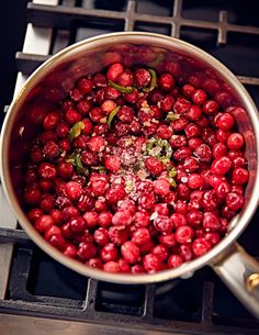 a pot filled with cranberries on top of a stove