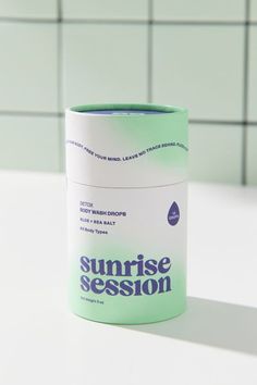 a green and white container sitting on top of a counter next to a tiled wall