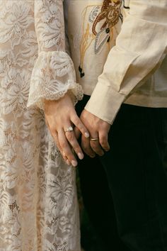 a close up of two people holding each other's hands while standing next to each other