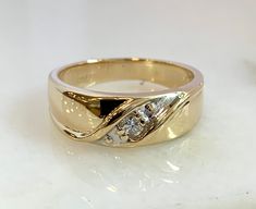 Here is a very appealing 14k yellow gold diamond band. This ring is set with one .15cttw round brilliant diamond. It is a nice touch that adds a little sparkle! Metal: 14k Yellow Gold Diamonds: 1-RB .15cttw Weight: 6.4 grams Size: 10 SKU# 20SB083719AGX If you have any questions on this item, please message us! GandDJewelers.etsy.com Please note that all of our pieces have been analyzed & identified by a Gemological Institute of America Certified Specialist. Additionally, our store is located Anniversary Gold-plated Yellow Gold Dome Ring, Hallmarked Yellow Gold Diamond Bangle, 14k Gold Multi-stone Diamond Ring Gift, Yellow Multi-stone 14k Gold Rings, Yellow Gold Diamond Bracelet, Channel Set, Gold Nugget Ring, Couple Ring Design, Gold Diamond Band, Couple Ring