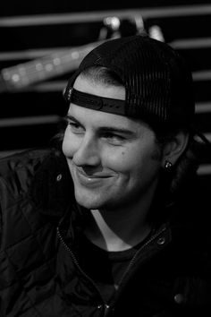 black and white photograph of a man wearing a hat smiling at the camera with his headband on