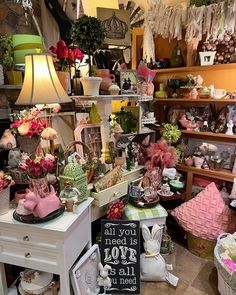 a room filled with lots of different types of items and decorations on display in front of a sign