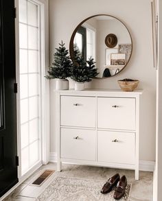 a pair of shoes sitting on the floor in front of a dresser with a mirror above it