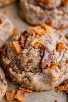 chocolate chip cookies are piled on top of each other with chunks of chopped walnuts