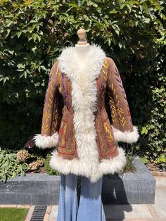 For more vintage items check my Instagram: @loeswardrobe Amazing handmade afghan coat with sheepskin and real suede, hand embroidery. 🐑 Inside is fully lined with soft sheepskin, trim is also 100% sheepskin These coats are handmade in Afghanistan by incredible numerous tailor's  Made out of re-used & recycled materials so some imperfections can occur! Major flaws will always be notified! Excellent condition! For reference: The model normally wears a M and is 1.68 tall. Please check measurements Vintage Hand-stitched Outerwear For Fall, Folk Style Fitted Fall Outerwear, Fitted Folk Outerwear For Fall, Fitted Folk Style Outerwear For Fall, Fitted Folk Style Fall Outerwear, Winter Festival Embroidered Outerwear, Vintage Embroidered Winter Outerwear, Bohemian Brown Outerwear With Faux Fur Lining, Vintage Brown Embroidered Outerwear