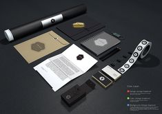 an assortment of stationery items displayed on a black surface with white and gold accents