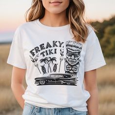 Show off your unique creepy style with the Freaky Tiki t-shirt. This unisex design is perfect for everyday trick-or-treating, after all it's Hula-ween all year around. This design features a franken-tiki, a hot-rod hearse, flaming skull tiki torches and tiki masks - everything you could possibly want! Black print on white t-shirt. AS Colour – Men’s Staple Regular Tee Made from beautifully soft 180 GSM 100% cotton (Grey marle 15% polyester), the t-shirt is super comfy with a great modern cut. Fea Tiki Mask, Tiki Torches, Black Print, Unisex Design, White Tshirt, White T, Hot Rods, T Shirt, Black