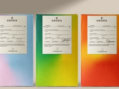 three colorful binders with papers attached to each one on the front and back of them