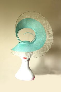 Hat Title - The Swirl (in green and ivory) An architectural shape that sits proud on the head of the wearer. Handmade with mint sinamay and outlined with checkered windowpane in ivory. The back of this hat is equally unique. Each angle of the hat looks different, providing different perspectives to the viewer. The hat adheres to your head via a millinery elastic.  This hat and almost all of my hats can be made in colours of your choice. Message me to discuss. The last photo shows this hat in Black and Gold. Luxury Green Wedding Costume Hats And Headpieces, Elegant Green Headpiece For Church, Elegant Green Costume Hats And Headpieces For Church, Green Summer Costume Hats And Headpieces For Church, Green Headpiece For Church And Royal Ascot, Green Costume Hats For Church And Kentucky Derby, Elegant Green Top Hat For Spring, Green Top Hat For Spring Church Occasion, Green Top Hat For Summer Church Events