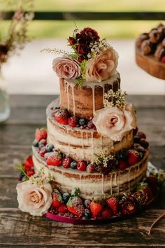 a three tiered cake with flowers and berries on top