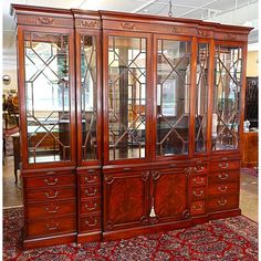 a large wooden china cabinet sitting on top of a rug