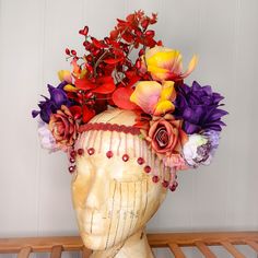 A stunning, statement floral headdress, with a variety of large purple, red, and yellow flowers and red foliage. A rigid band sits across the forehead with a row of delicate red beaded fringing. Made using artificial flowers and foliage, this piece will ensure you stand out from the crowd. At the back, there are two bands of elastic which secure the headdress and make it adjustable and comfortable to wear.  A standout piece that would be a fantastic addition to your festival wardrobe, fancy dres Multicolor Bohemian Hair Accessories For Spring, Bohemian Multicolor Hair Accessories For Spring, Spring Bohemian Multicolor Hair Accessories, Multicolor Festival Headpieces For Summer, Bohemian Carnival Headband, Summer Adjustable Flower Decoration Headpieces, Summer Adjustable Headpieces With Flower Decoration, Adjustable Multicolor Headpieces For Summer, Adjustable Summer Headpiece With Flower Decoration