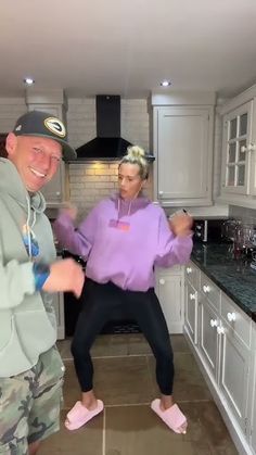 the man and woman are dancing in the kitchen