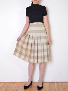 Cool vintage skirt made of gently textured, matte fabric - woven with plaid pattern in tones of beige and white. Flared, a line midi fit. Button and zip closure on the back. Unlined. The item has been pinned on the model Era: 70's Fabric: not given, feels like cotton to touch Condition: very good Estimated size: L / XL (please, check the measurements) Measurements (measured flat, need to be doubled to get the circumference): Waist: 45 cm / 17,7 inches Length: 72 cm / 28,3 inches Beige A-line Pleated Skirt For Fall, Summer Plaid Pleated Skirt, Fall Cotton Midi Pleated Skirt, Fall Cotton Pleated Midi Skirt, Casual Beige A-line Pleated Skirt, Classic Box Pleat Pleated Skirt For Summer, Classic Pleated Plaid Skirt, Chic Pleated Plaid Skirt, Casual A-line Pleated Skirt With Accordion Pleats