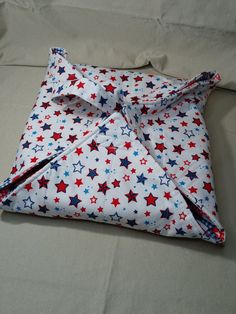 a red, white and blue shirt with stars on it is laying on a bed