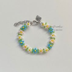 "Handmade Beaded Bracelet  ✿ Made with glass seed beads and metal accents ✿ Sky blue, yellow, milky white, light pink, and matte lime green ✿ The bracelet has 1.5\" of extension chain" Spring Beaded Pearl Bracelet With Round Beads, Handmade Pearl Bracelet With Round Beads For Spring, Handmade Pearl Bracelet For Spring, Blue Spring Jewelry For Friendship, White Spring Jewelry With Tiny Beads, Spring White Jewelry With Tiny Beads, Yellow Beaded Bracelets With Round Beads For Spring, Handmade Blue Beaded Bracelets For Spring, Blue Beaded Bracelets For Spring