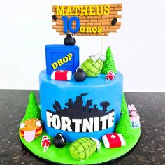 a birthday cake is decorated with items from the video game fortnite on it