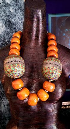 If you are seeking a piece with that massive WOW FACTOR, this Moroccan Resin Tribal Necklace is for you!! This Huge Berber Egg Ethnic Chest Piece features the large and scarce metal Berber Egg beads with 6" circumference, each. The Moroccan Resin Beads (average = 1.5" x 1.25") are a warm soft caramel or brown-orange and are separated from one another with Aurora Borealis Rhinestone Rondelles adding brilliance and light. This Oversized Beaded Statement Necklace will lay best on a smaller busted woman, since it pulls/rolls to the left or right with fuller busts. Ideally, these Bold Chunky Heavy Men's Warrior Beads will sit best on a male torso. The Boho Couture Neck Candy is finished with Tibetan Resin Capped Beads and Ornate Silvertone Tribal beads. Adjusts from 29-31" with an xl lobster cl Traditional Beaded Necklaces For Rituals, Artisan Beads For Rituals And Festivals, Traditional Wooden Beaded Necklaces For Festivals, Traditional Orange Beaded Necklaces For Festivals, Traditional Orange Beaded Necklace For Festival, Artisan Beads For Ceremonial Festivals, Traditional Orange Beads For Festival, Wooden Beads For Festival, Traditional Large Beads For Rituals