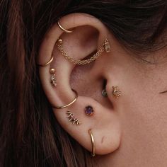 a close up of a person with ear piercings on their ears and behind the ear